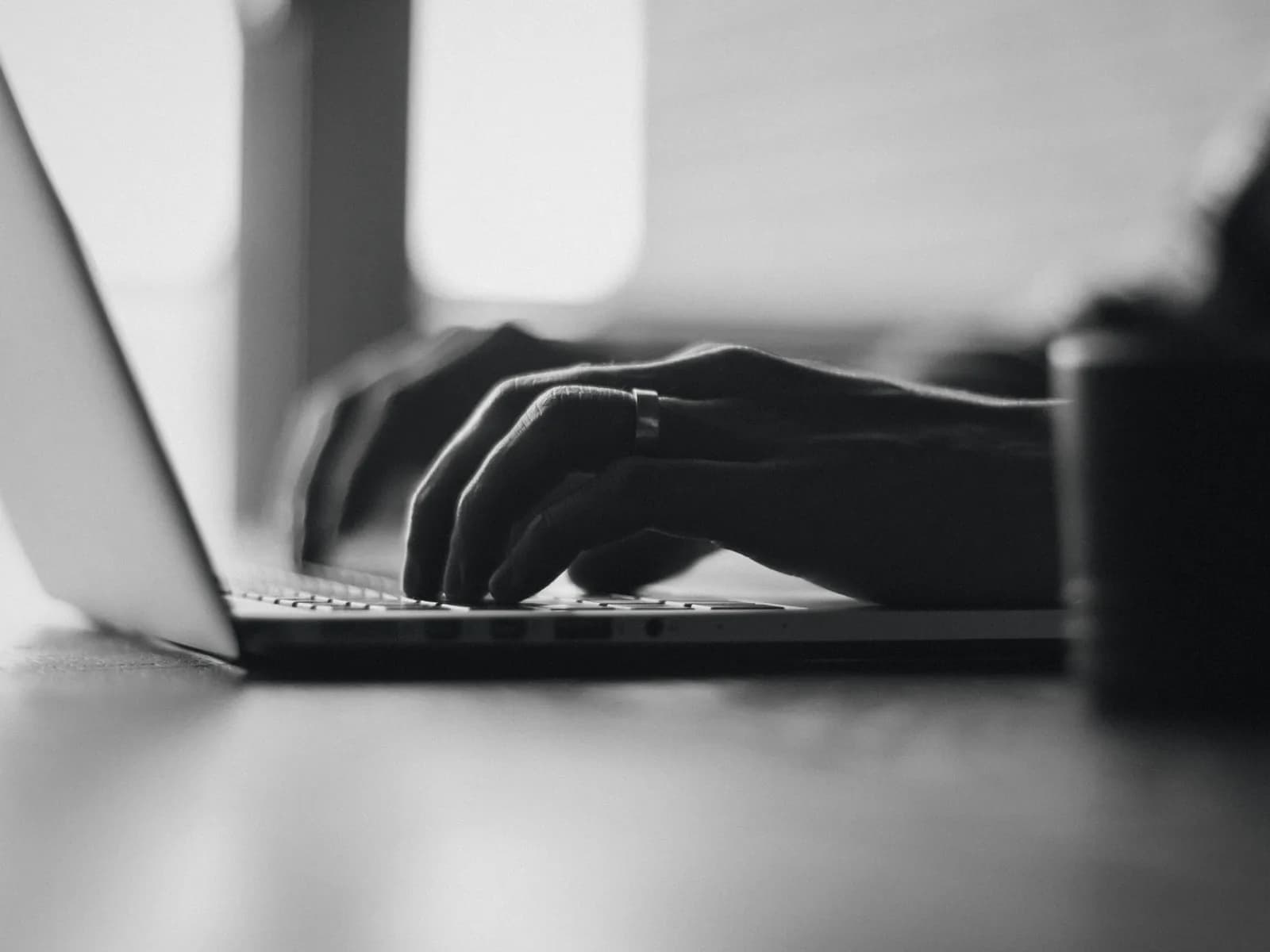 Hands on a laptop keyboard in soft light